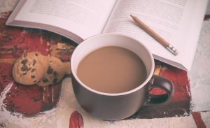 coffee-cup-and-cookies-on-table-with-book-in-background