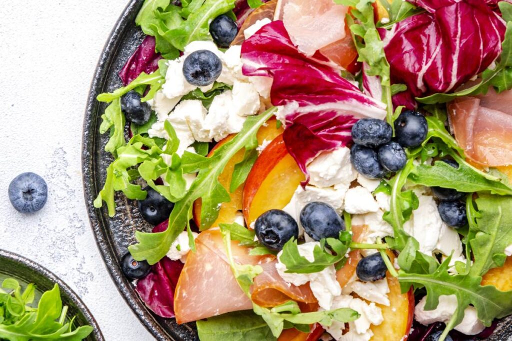 Šalát s kozím syrom, broskyňami a čučoriedkami. Foto: Envato