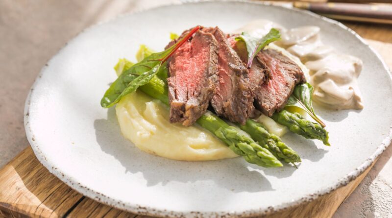 Hovädzí steak so zemiakovým pyré, špargľou a hubovou omáčkou.
